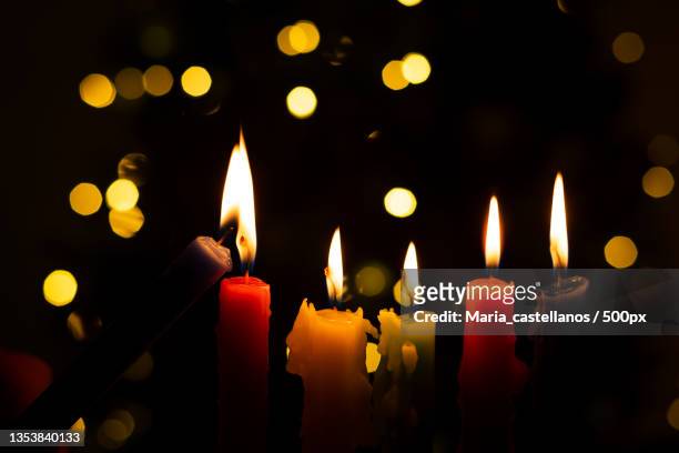 close-up of illuminated candles against black background - maria castellanos stock pictures, royalty-free photos & images