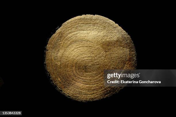 a beautiful smear of gold paint in the form of a plaque on a black isolated background. - brushed gold background foto e immagini stock