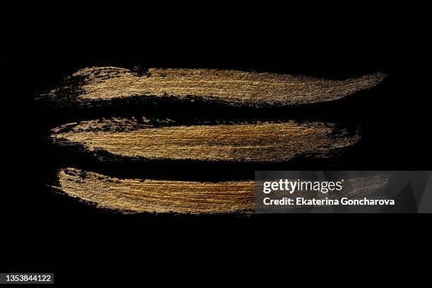 a beautiful smear of gold paint in the form of a plaque on a black isolated background. - gold plaque stock pictures, royalty-free photos & images