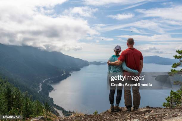 hiking couple relax on coastal cliff, in autumn - travel and canada and fall stockfoto's en -beelden