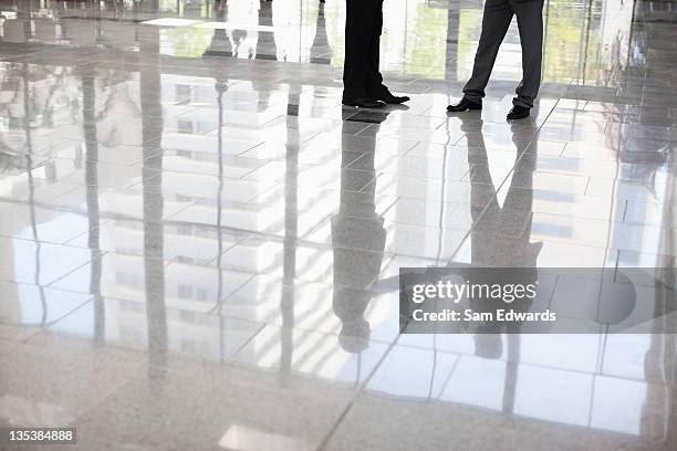 empresarios de pie juntos en el lobby - parte inferior fotografías e imágenes de stock