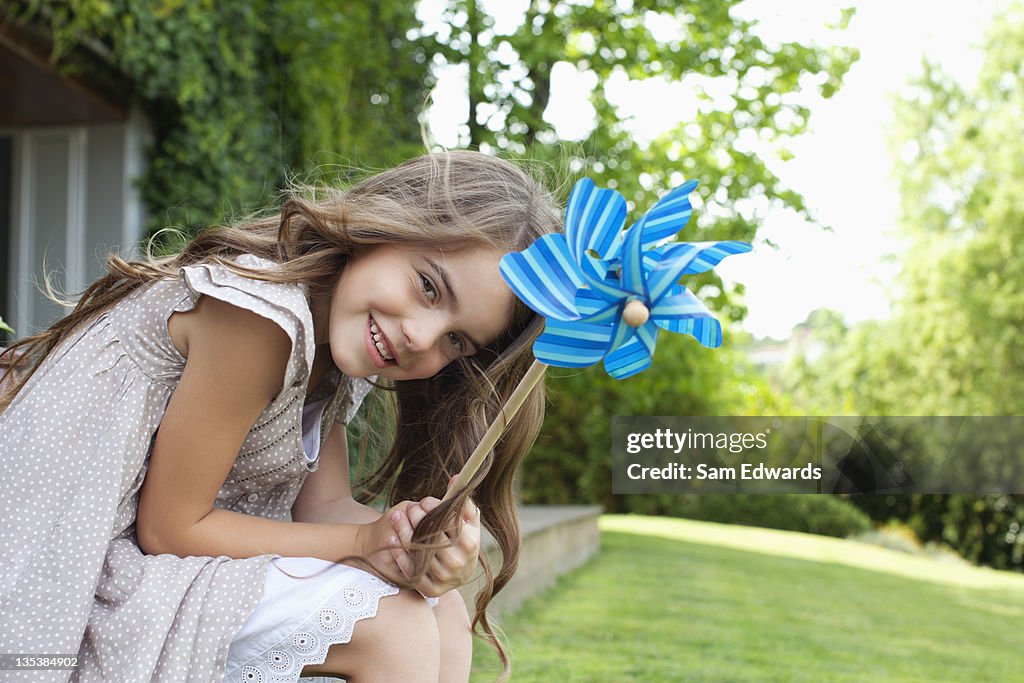 Girl in backyard holding pinwheel