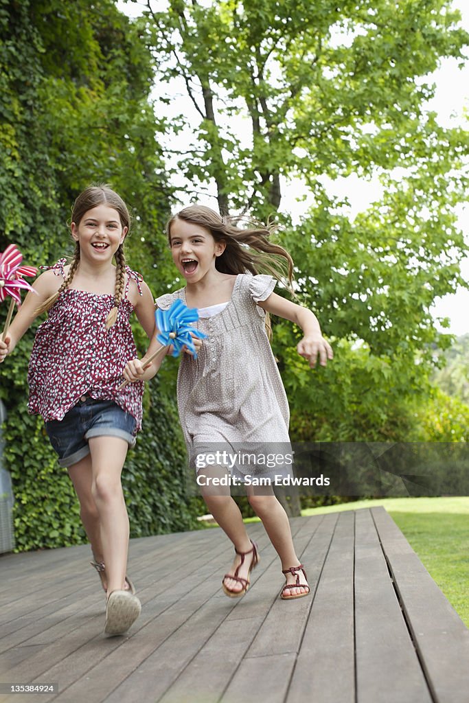 Girls running holding pinwheels