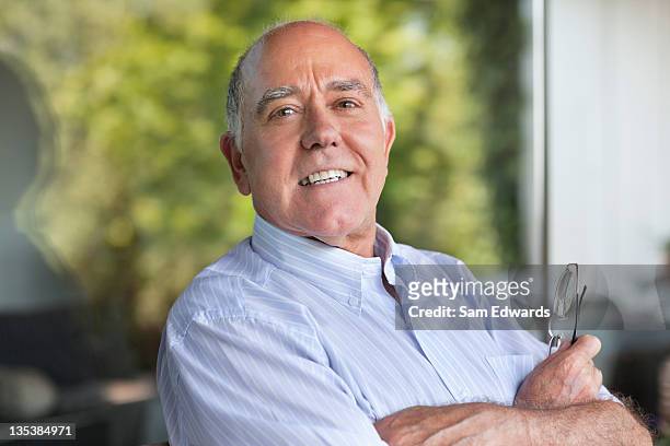 smiling man with arms crossed - 60 64 years stock pictures, royalty-free photos & images