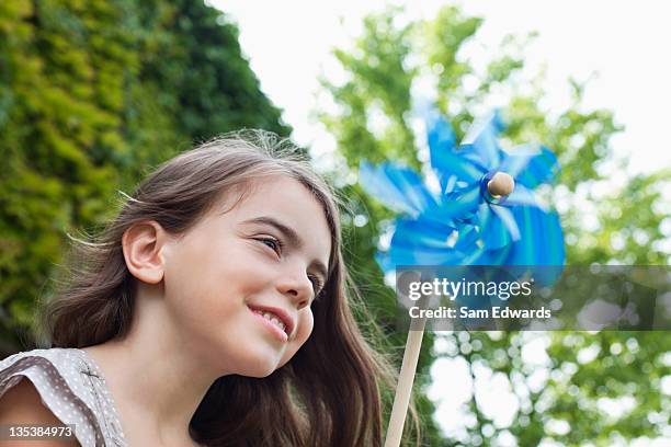 smiling girl holding pinwheel outdoors - paper windmill bildbanksfoton och bilder