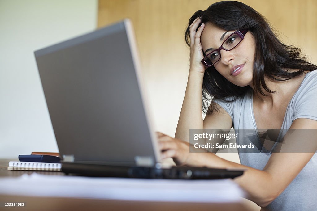 Frustrated woman using laptop