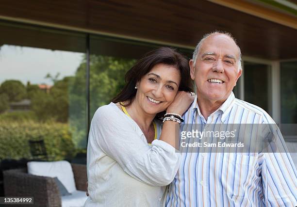 smiling couple standing on patio - baby boomer stock pictures, royalty-free photos & images