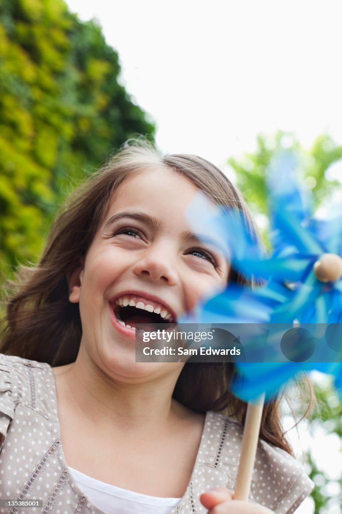 Grinning Menina segurando Cata-vento de papel