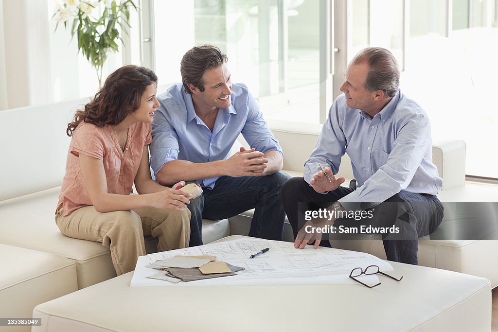 Couple sitting on sofa talking to financial advisor