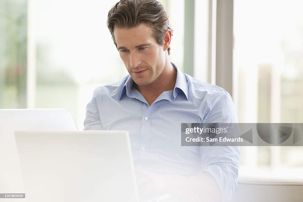 Serious businessman using laptop