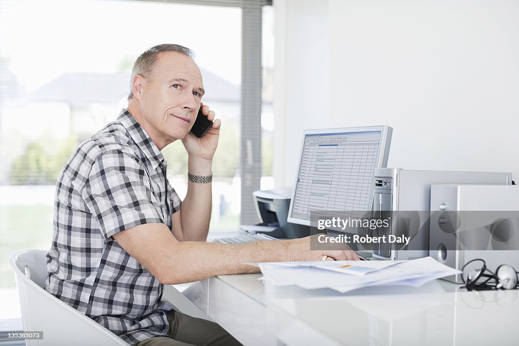 Man sitting at desk using cell phone