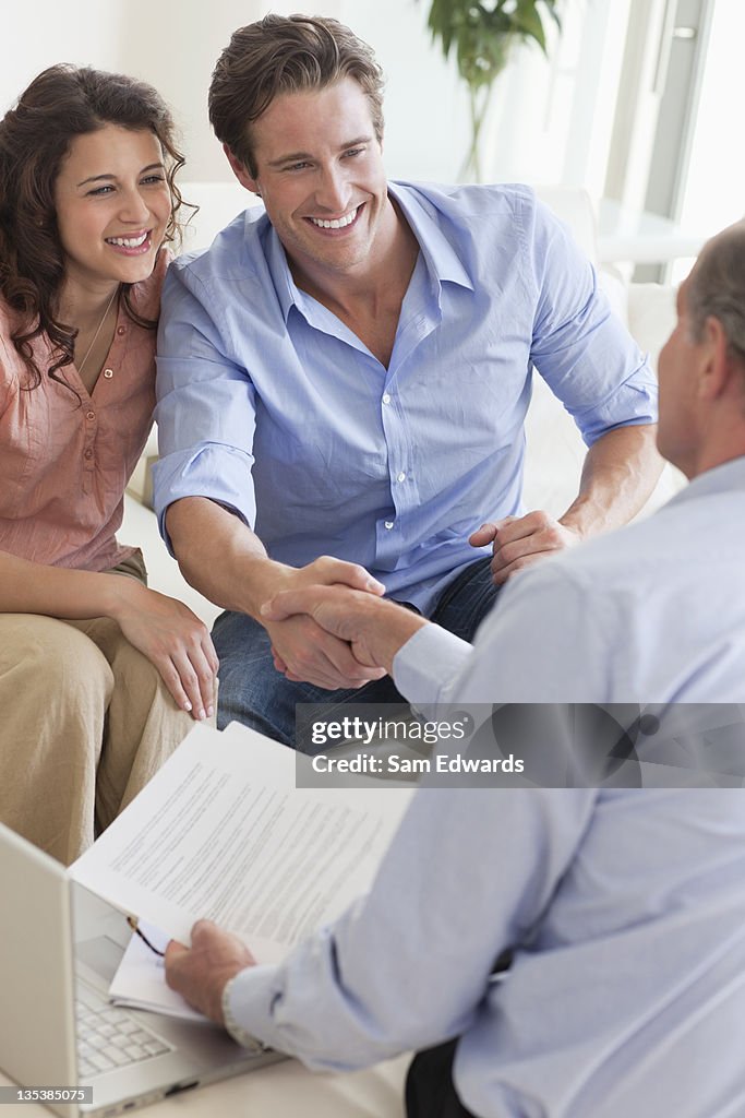 Couple shaking hands with financial advisor