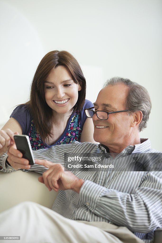 Father showing cell phone to daughter