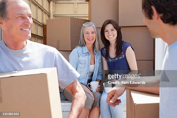 woman drinking coffee on back of moving van - senior moving house stock pictures, royalty-free photos & images