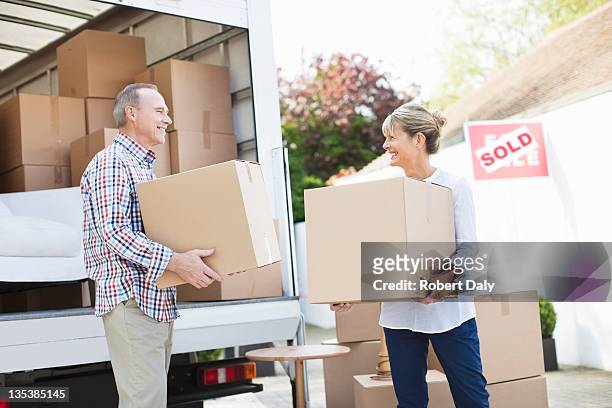 couple unloading boxes from moving van - moving truck stock pictures, royalty-free photos & images