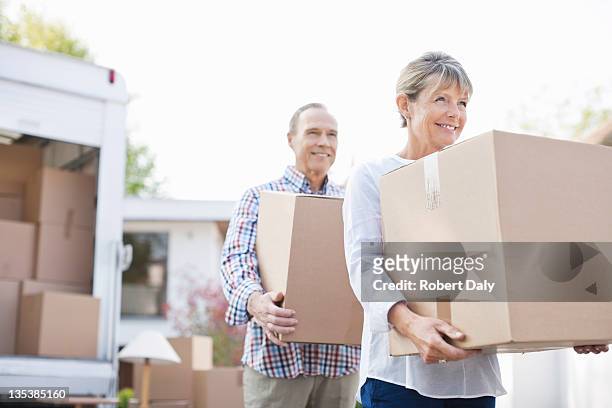 couple unloading boxes from moving van - senior moving house stock pictures, royalty-free photos & images