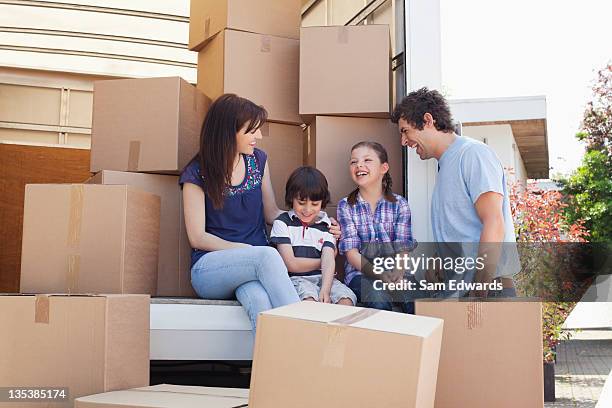 family sitting on back of moving van - family moving up stock pictures, royalty-free photos & images