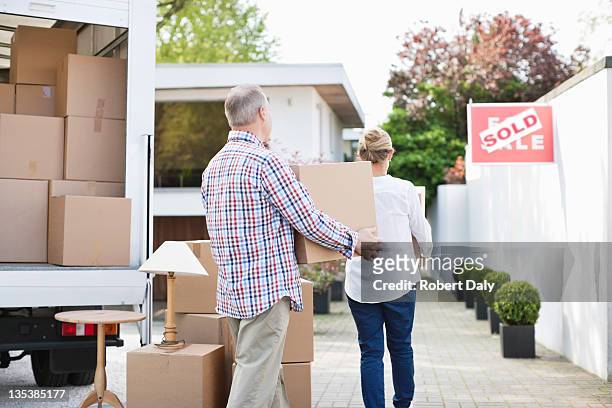 couple unloading boxes from moving van - baby boomer home stock pictures, royalty-free photos & images