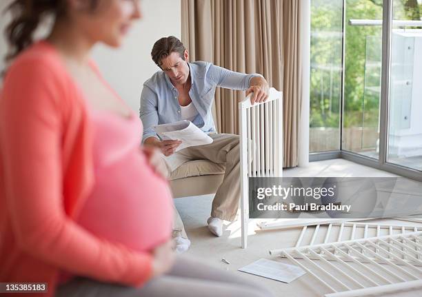 husband putting together crib - baby crib stock pictures, royalty-free photos & images