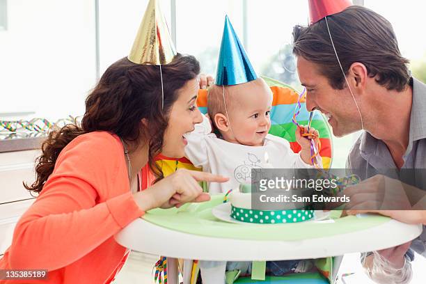parents and baby celebrating first birthday - eerste verjaardag stockfoto's en -beelden