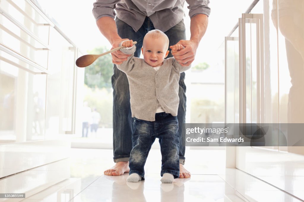 Father helping son learn to walk