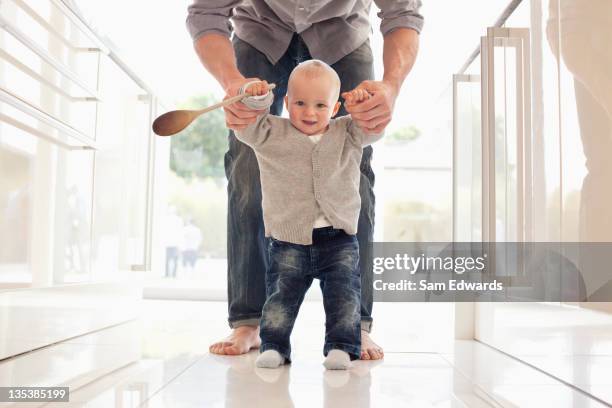 pais ajudando o filho aprender a andar - family walking sam edwards - fotografias e filmes do acervo