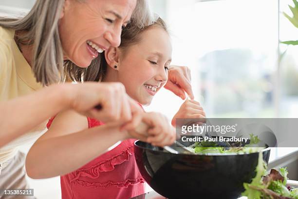 grandmother and granddaughter preparing salad - generation gap 個照片及圖片檔
