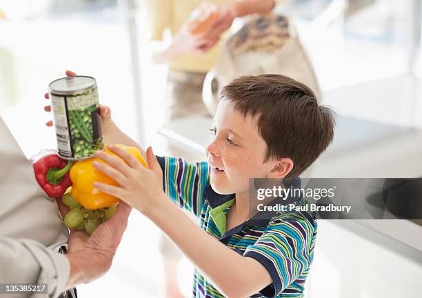 boy stacking food into grandfather - young man groceries kitchen stockfoto's en -beelden