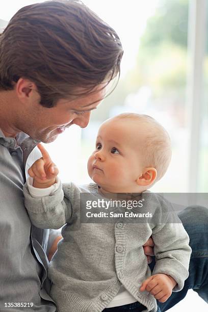 smiling father sitting with son - baby pointing stockfoto's en -beelden