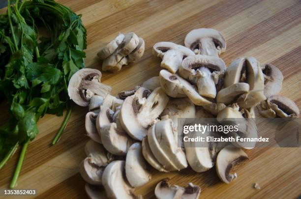 sliced raw fresh white champignon mushrooms on wooden cutting board - champignon stock-fotos und bilder