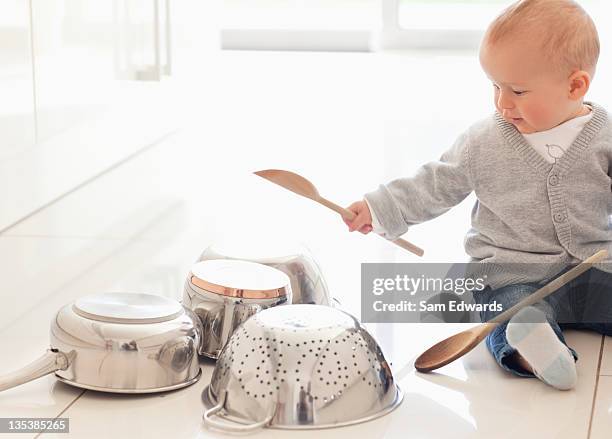 baby banging on pots with wooden spoon - baby sussex stockfoto's en -beelden