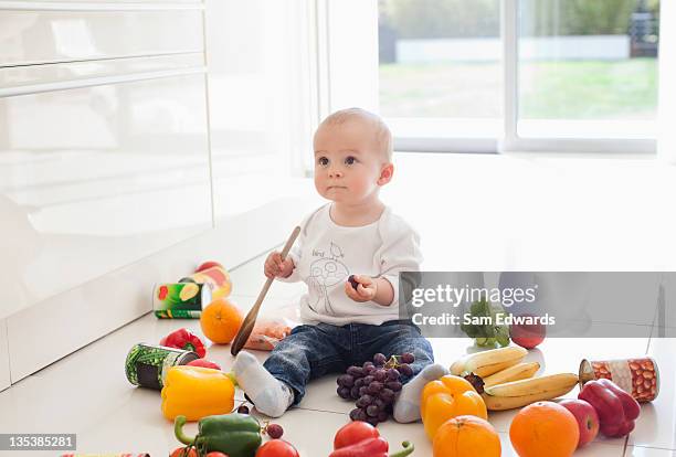 bebé que juega en el suelo con alimentos - baby food fotografías e imágenes de stock