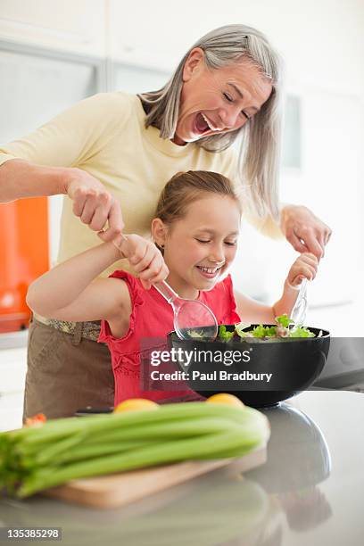 grandmother and granddaughter preparing salad together - mature adult cooking stock pictures, royalty-free photos & images