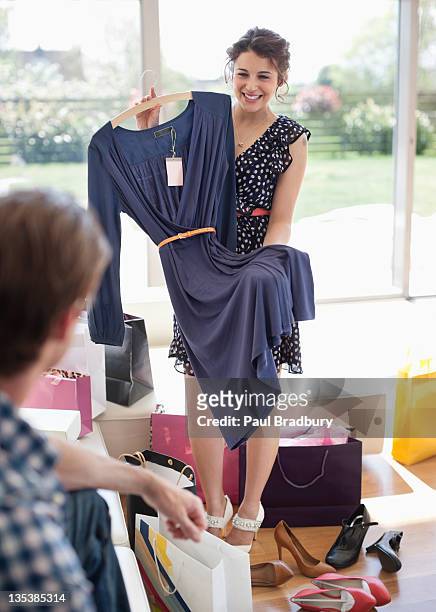 woman showing dress to husband - home fashion show stock pictures, royalty-free photos & images
