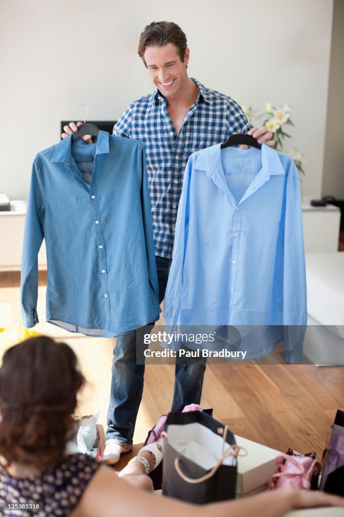 Man showing new shirts to wife