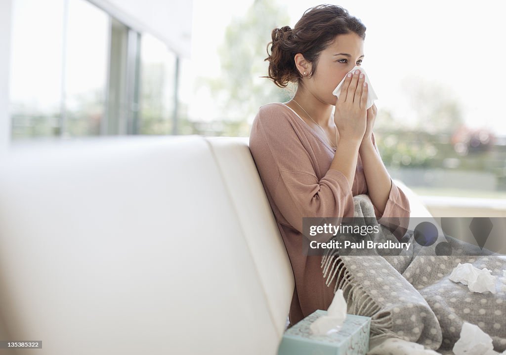 Sick woman blowing her nose