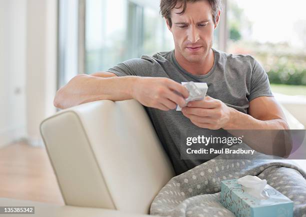 sick man checking medicine package - box of tissues stock pictures, royalty-free photos & images