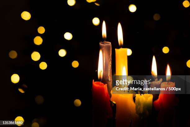 close-up of illuminated candles against black background - maria castellanos stock pictures, royalty-free photos & images