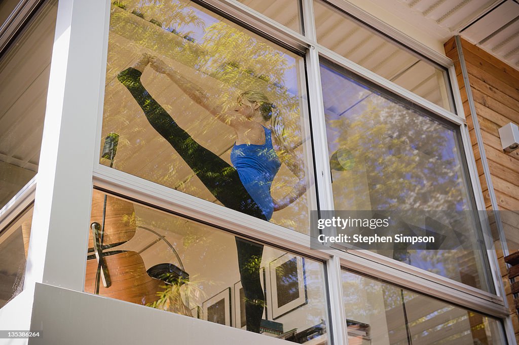 Woman doing yoga in her living room