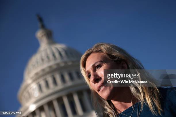 Rep. Marjorie Taylor Greene answers questions in front of the House steps while House Minority Leader Kevin McCarthy holds a press conference...