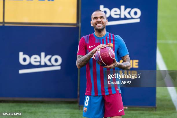 Dani Alves poses for photo with T-Shirt of FC Barcelona during his presentation as new player of FC Barcelona at Camp Nou stadium on November 17 in...