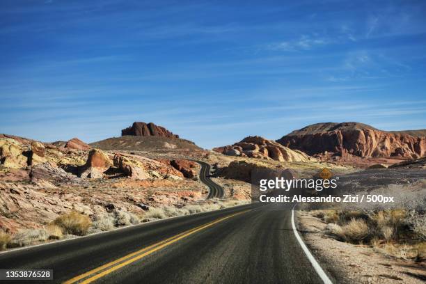 empty road leading towards mountains against blue sky,arizona,united states,usa - wüstenstraße stock-fotos und bilder