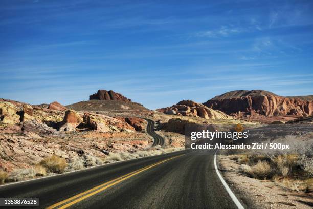 empty road leading towards mountains against blue sky,arizona,united states,usa - desert road foto e immagini stock