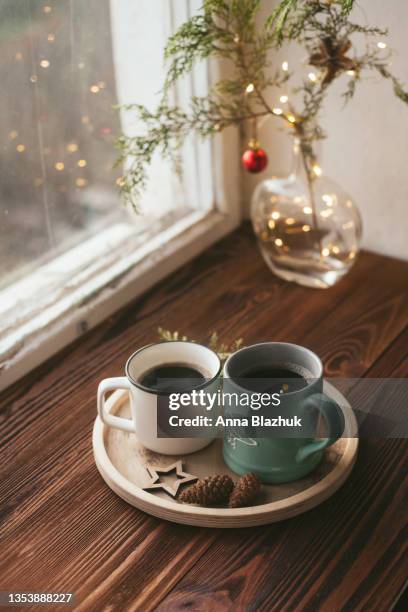 home interior details, natural christmas decoration for home, made of tree branch, two cups of coffee, winter hot drink on wooden window sill. - christmas coffee stock pictures, royalty-free photos & images