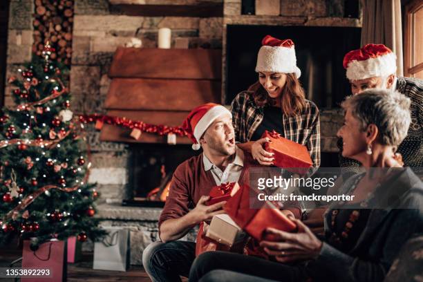 happiness two generation family on the sofa for christmas - exchanging gift stock pictures, royalty-free photos & images