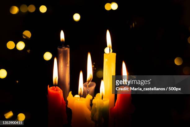 close-up of illuminated candles in darkroom - maria castellanos stock pictures, royalty-free photos & images