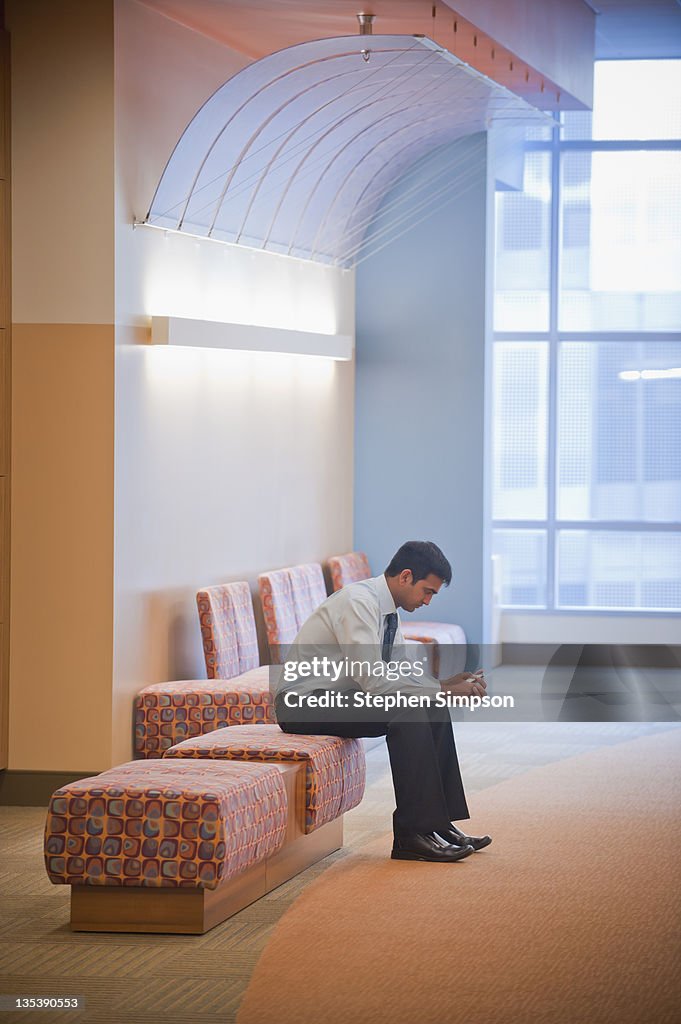 Businessman with cell phone in lobby