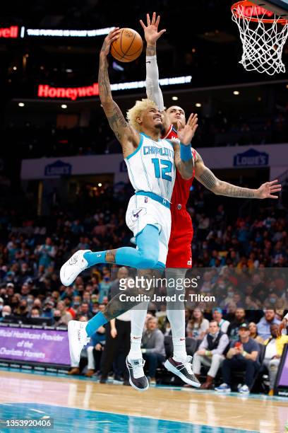 Kelly Oubre Jr. #12 of the Charlotte Hornets attempts a dunk on Kyle Kuzma of the Washington Wizards during the second half of their game at Spectrum...