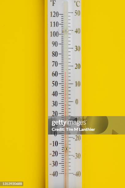 thermometer against yellow background - fahrenheit stock pictures, royalty-free photos & images