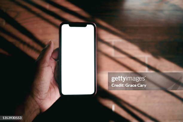 woman holds smart phone with blank screen - hand holding phone stockfoto's en -beelden